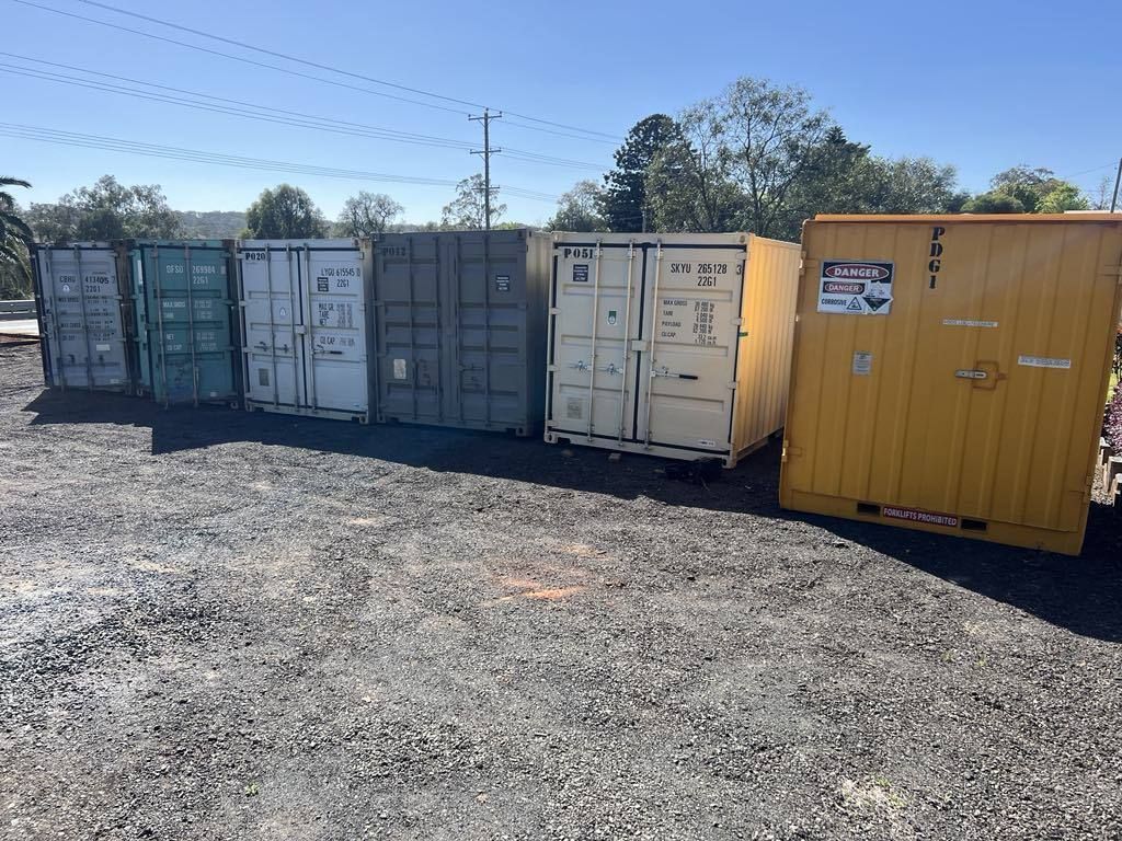 A Row of Shipping Containers Are Lined Up in a Gravel Lot — Toowoomba Container Hire & Sales in Highfields, QLD