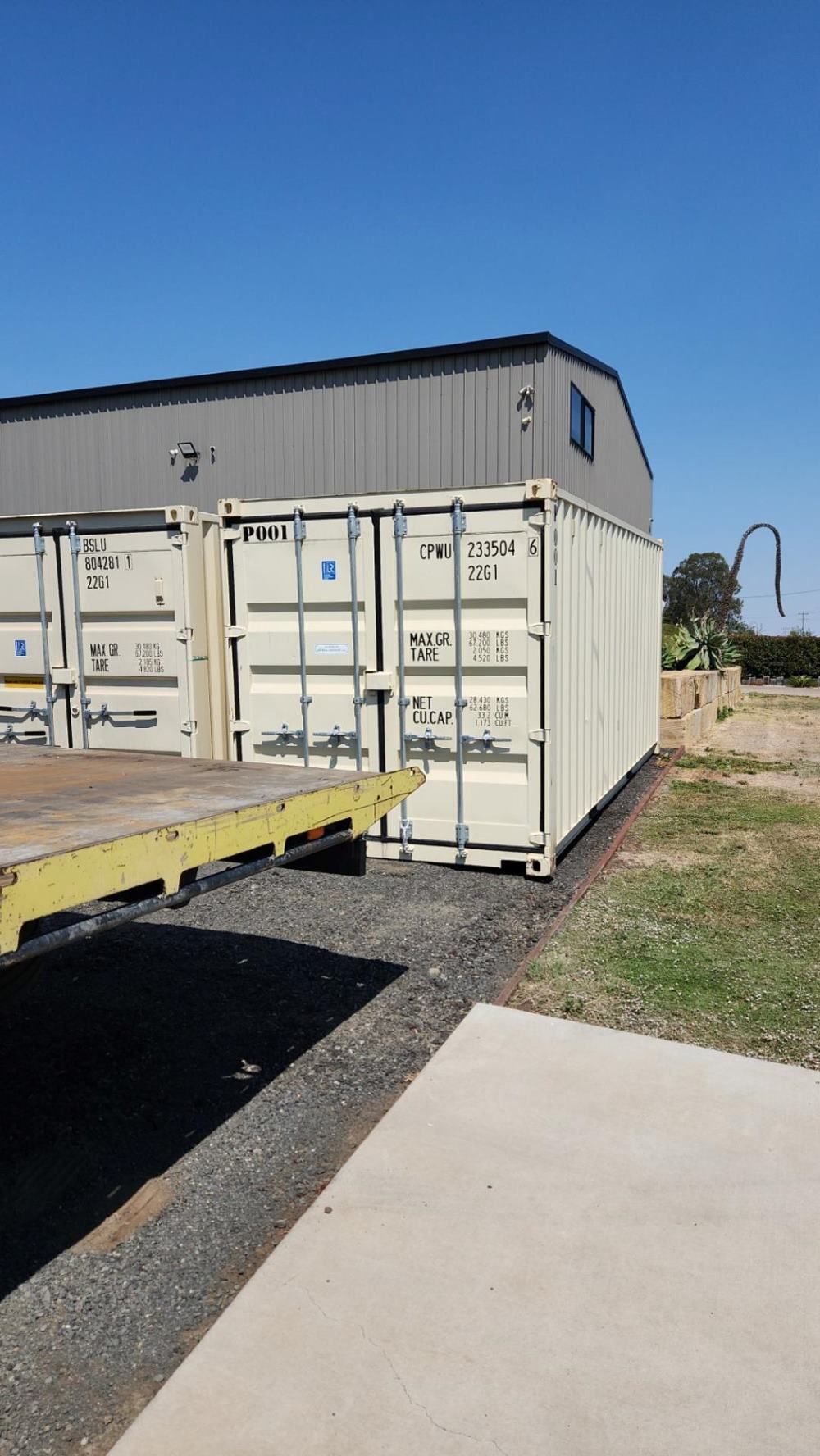 A White Shipping Container is Parked in Front of a Building — Toowoomba Container Hire & Sales in Wilsonton, QLD