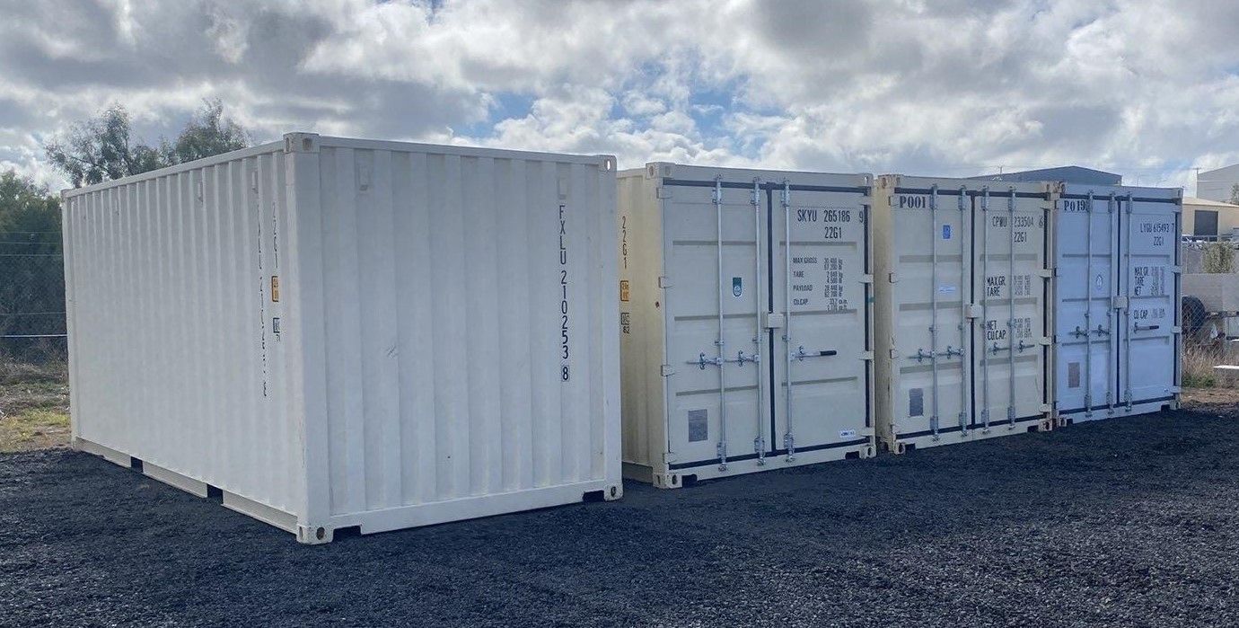 A Row of Shipping Containers Are Lined Up in a Gravel Lot — Toowoomba Container Hire & Sales in Wilsonton, QLD