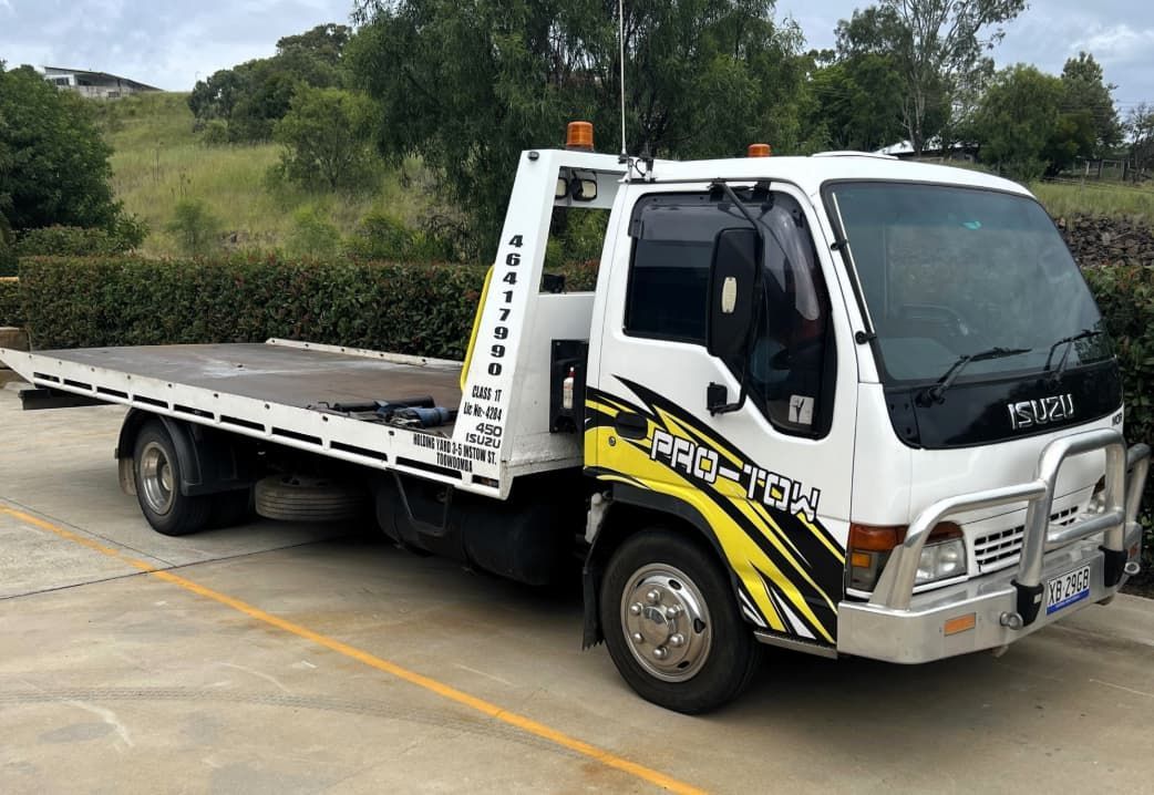 A White and Yellow Tow Truck is Parked in a Parking Lot — Toowoomba Container Hire & Sales in Wilsonton, QLD
