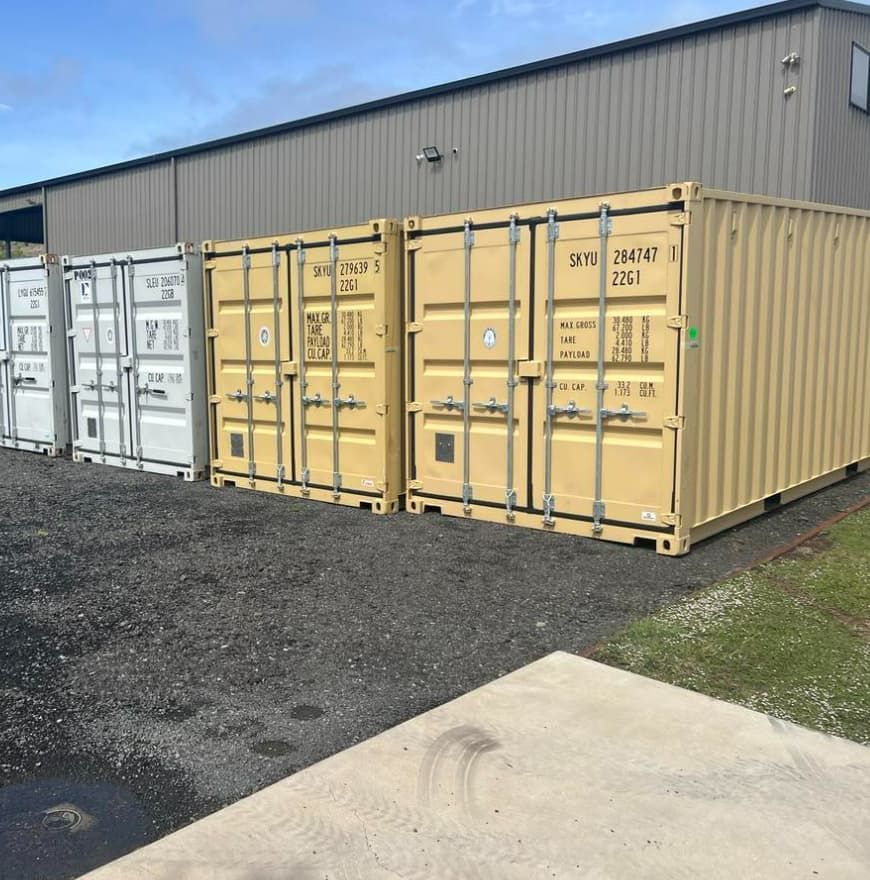 A Row of Shipping Containers Are Lined Up in Front of a Building — Toowoomba Container Hire & Sales in Highfields, QLD