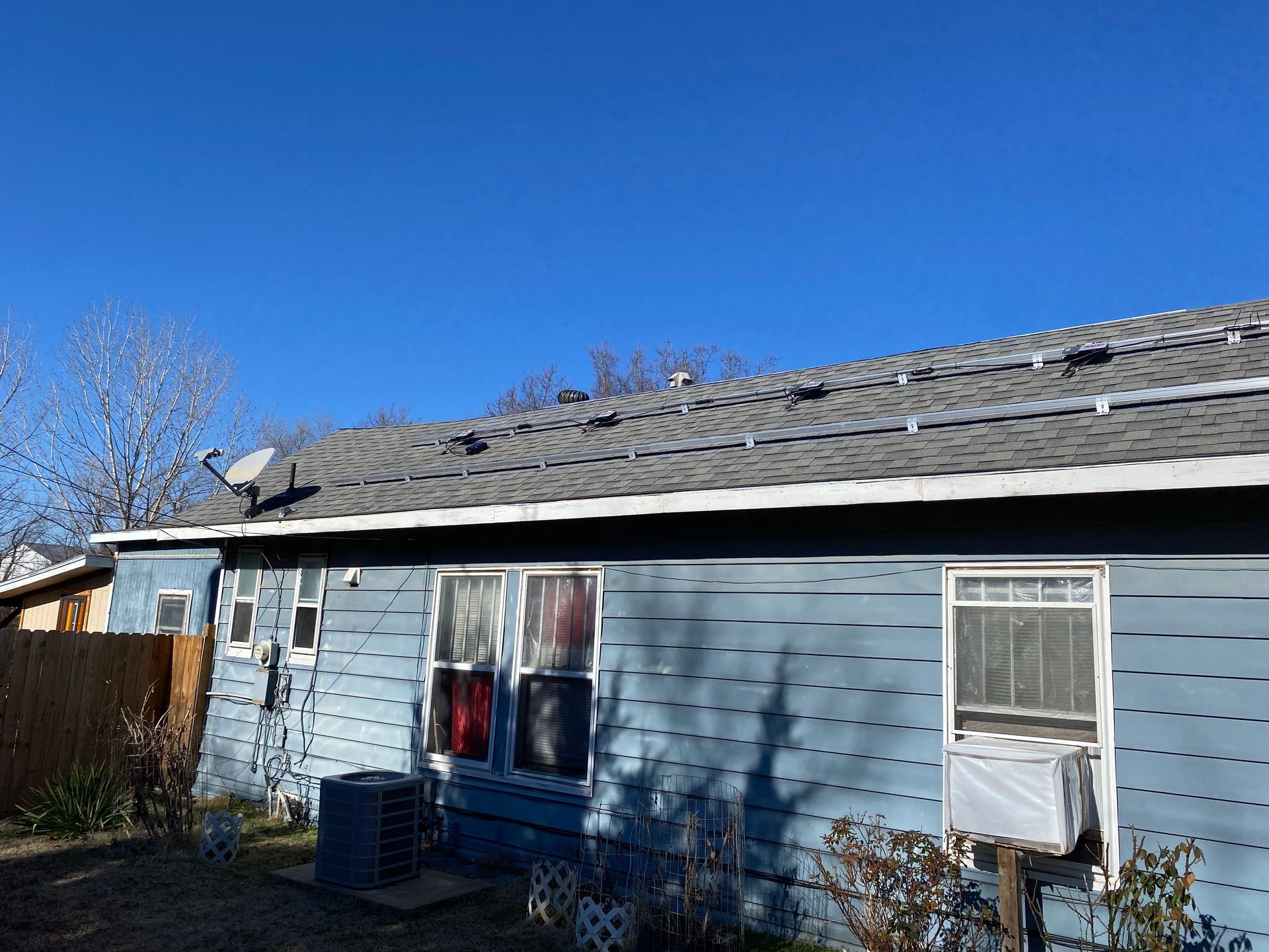 A blue house with a roof that has solar panels on it.