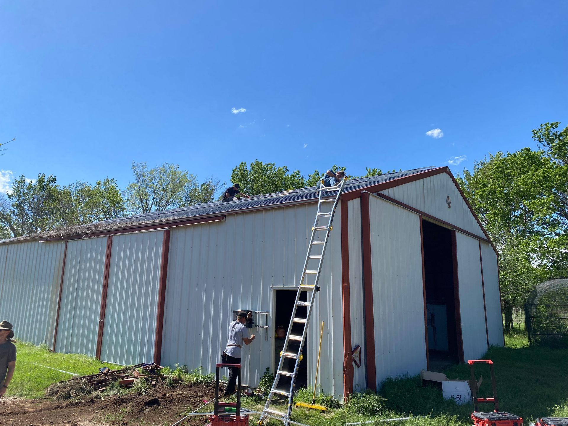 A man on a ladder is working on the roof of a building.