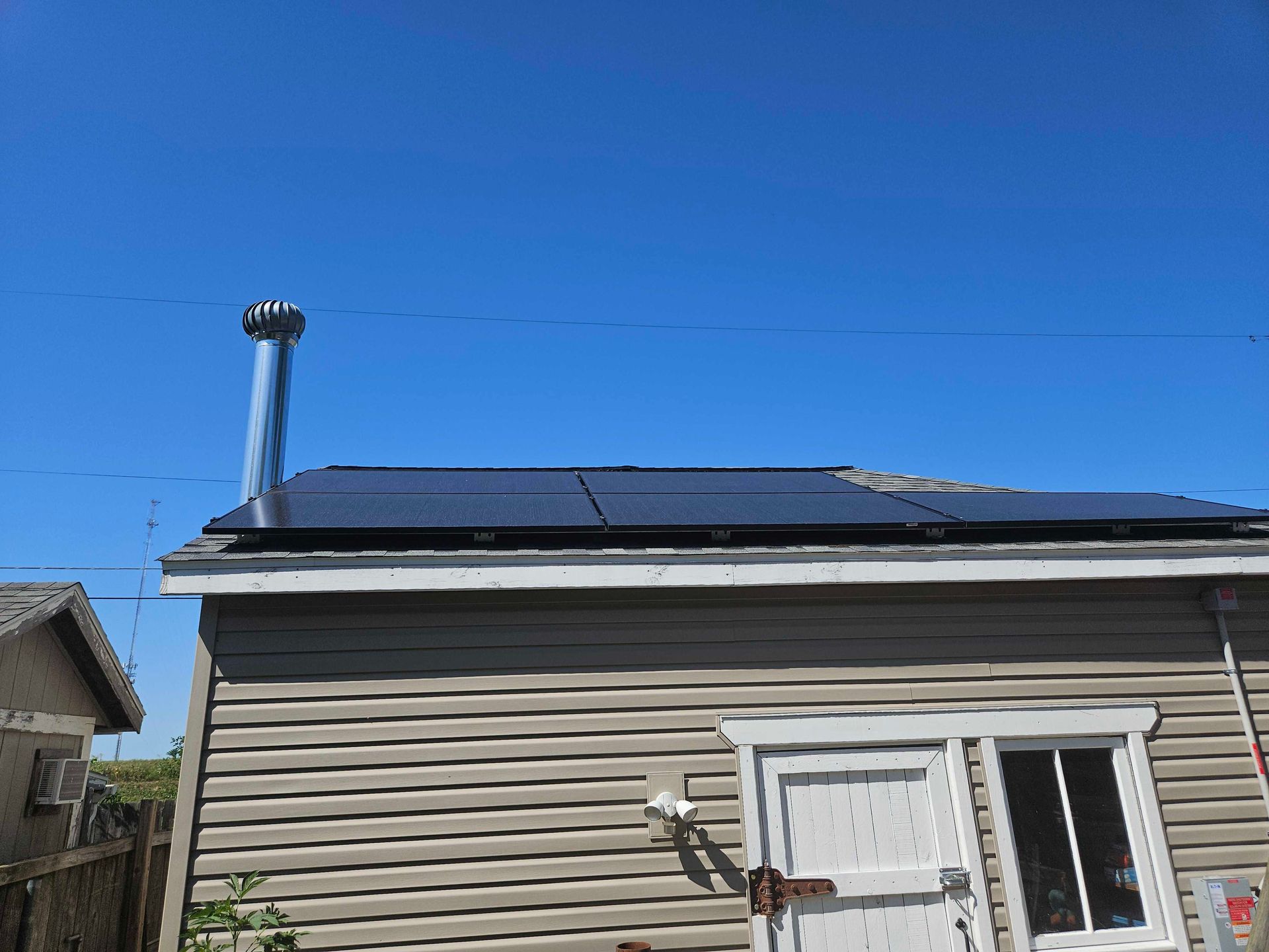 A house with solar panels on the roof and a chimney.