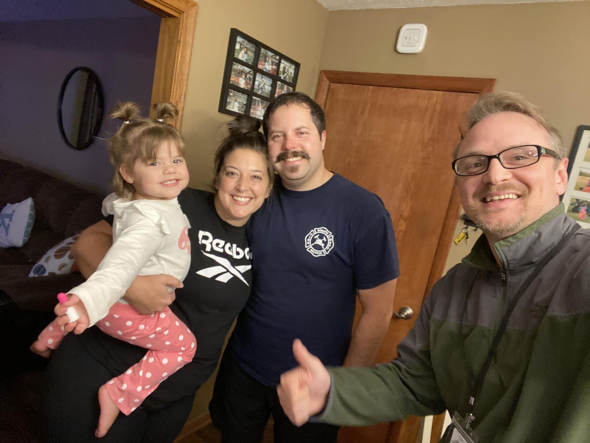 A group of people are posing for a picture in a living room.