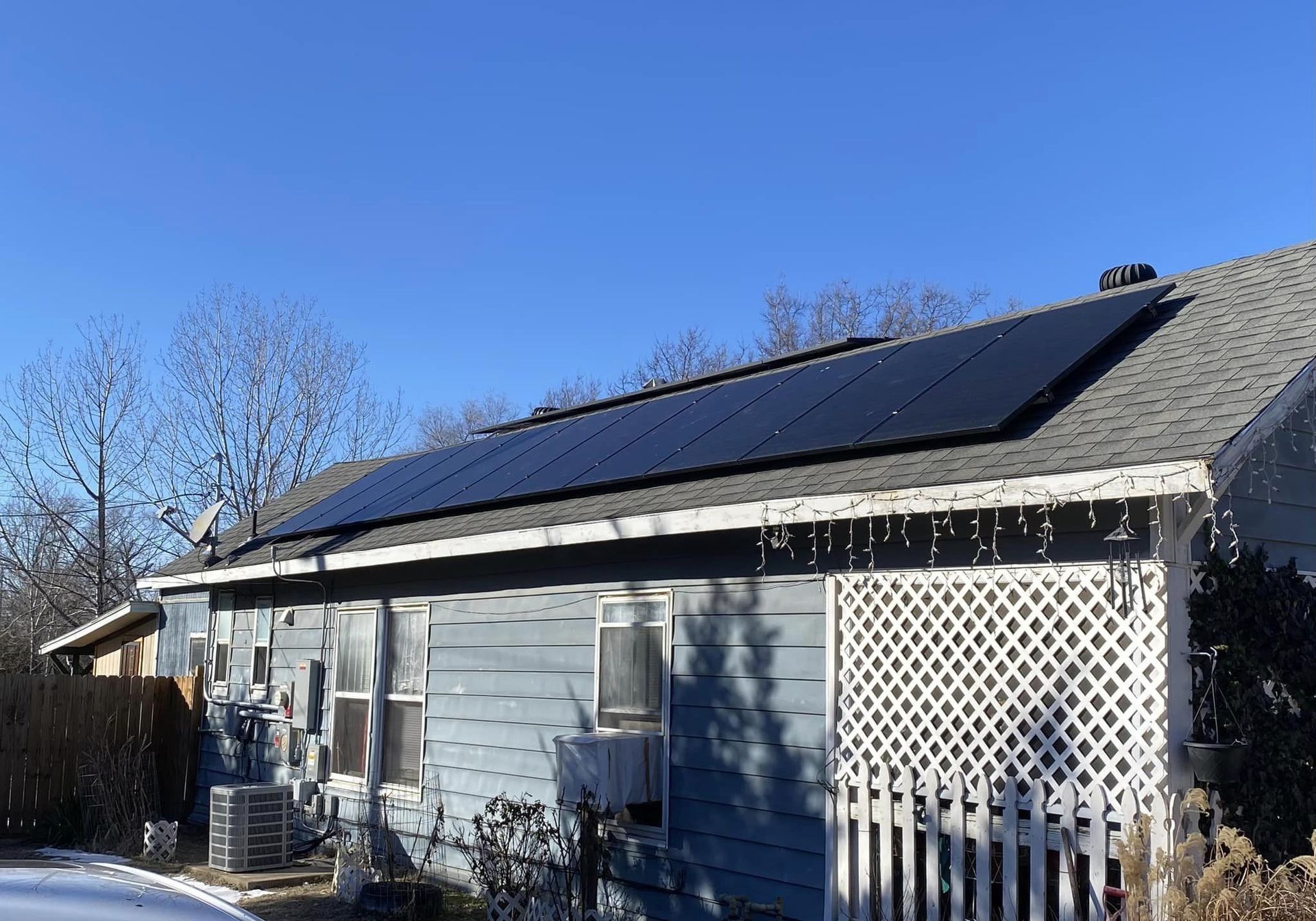 A blue house with solar panels on the roof.