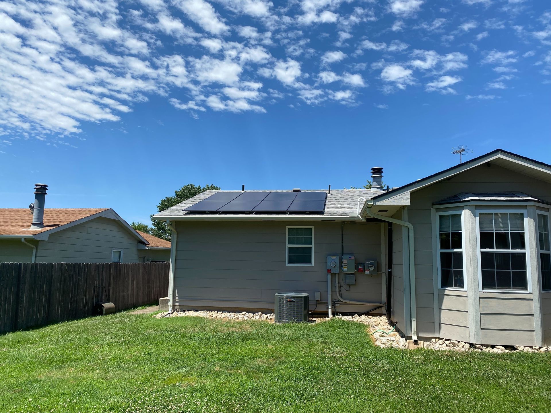 The back of a house with solar panels on the roof.