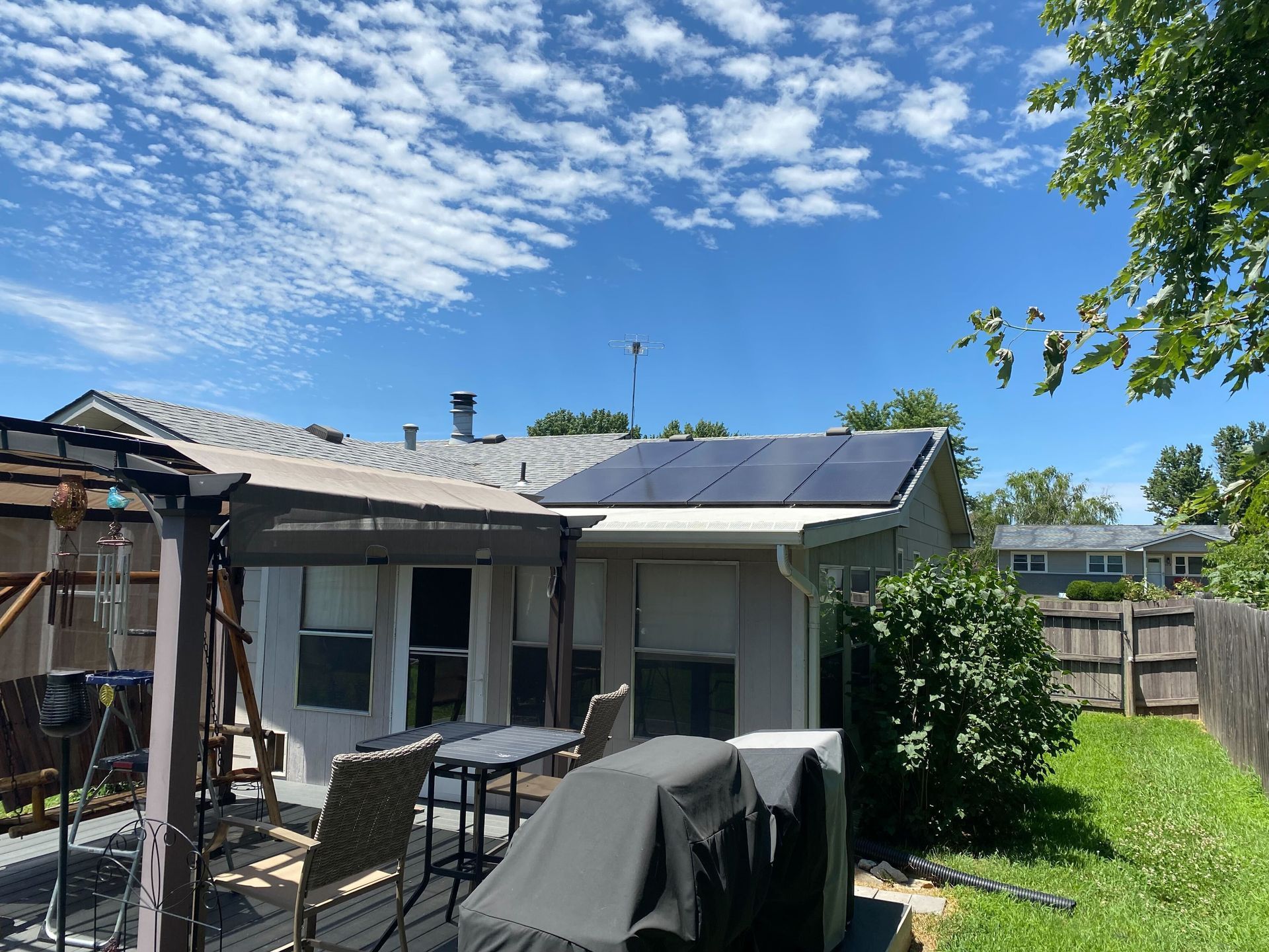 A house with a pergola and solar panels on the roof.