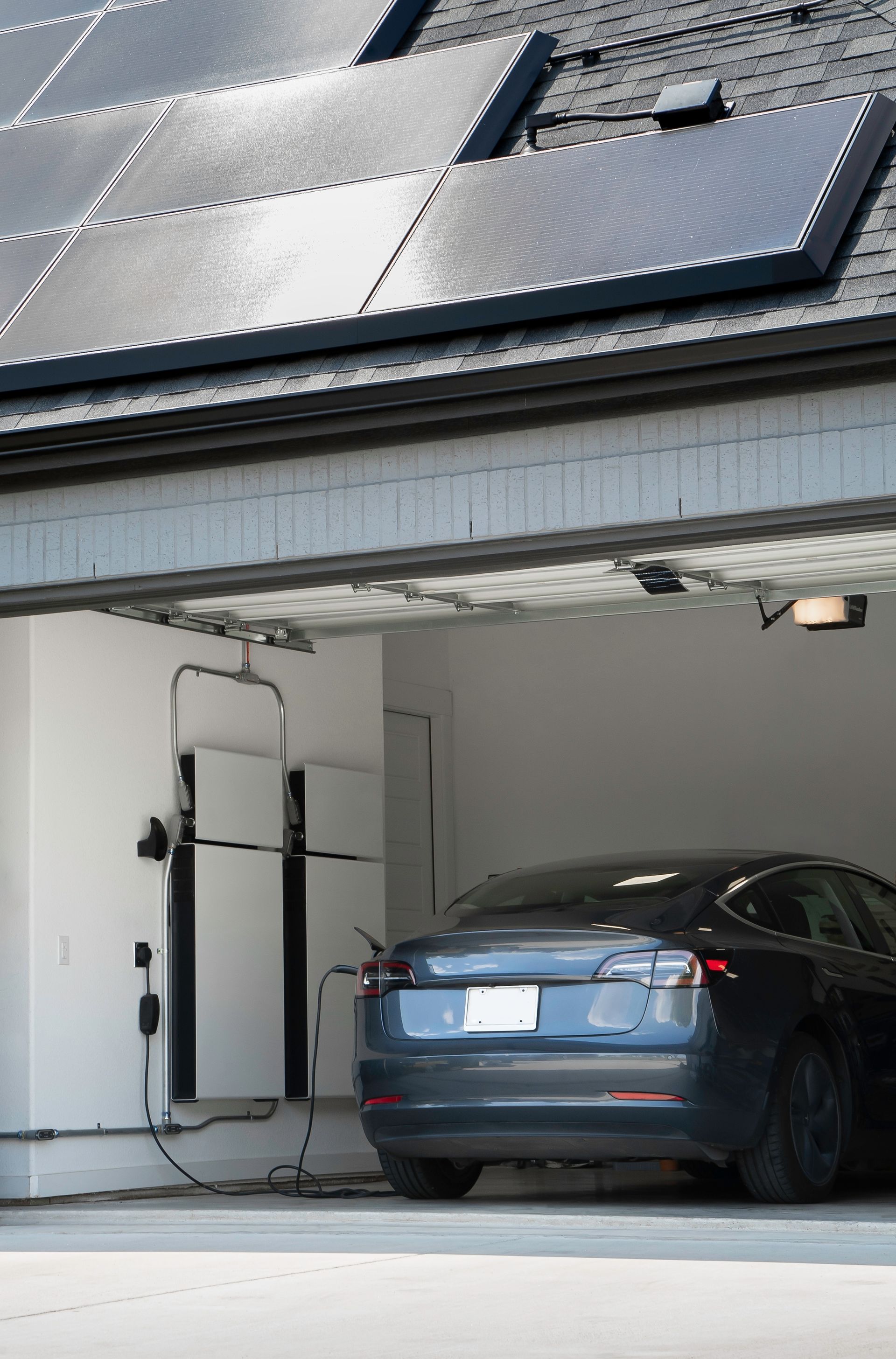 A car is parked in a garage with solar panels on the roof