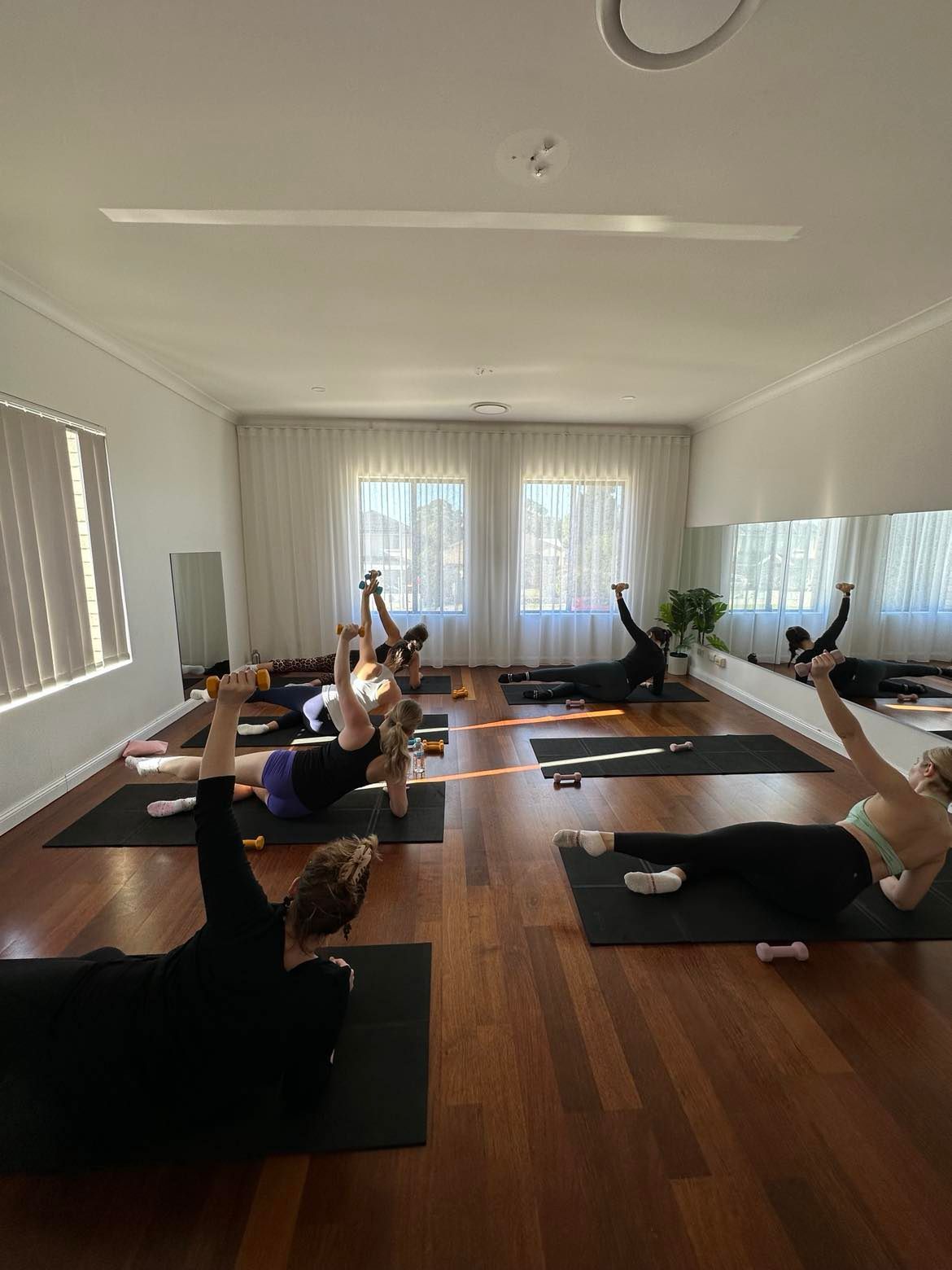 A group of people are doing yoga in a room.