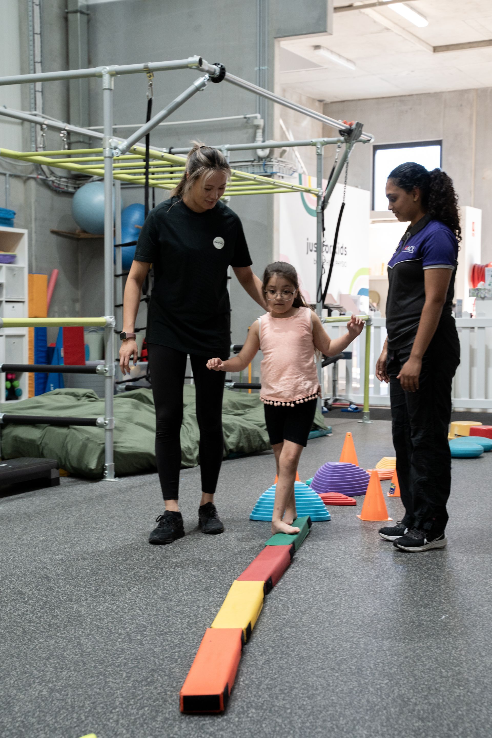 Child with gross motor delay play with hurdles