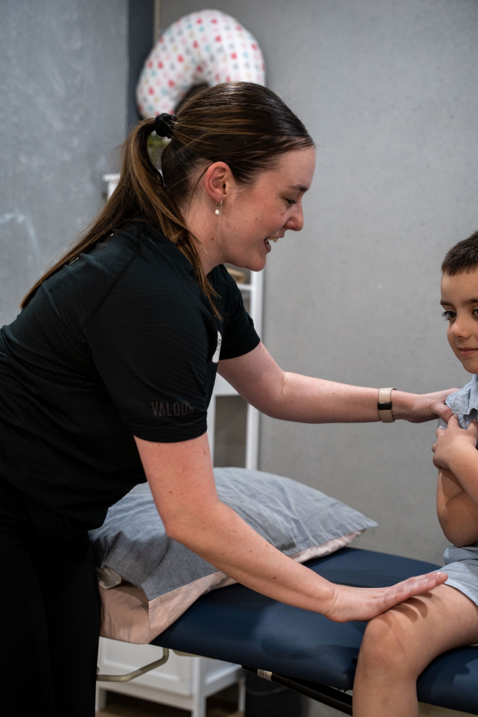 Kids physio assessing 5 year old boys back range of motion