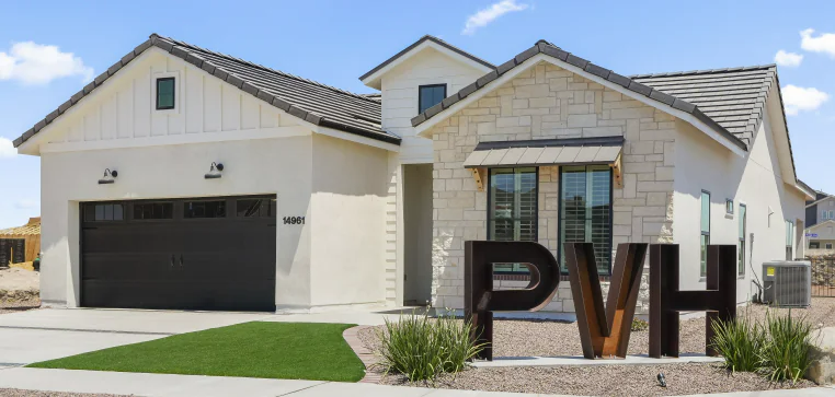 Modern home with stone and white facade; PVH sign in front.
