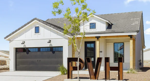 White house with black garage door and sign reading F V H.