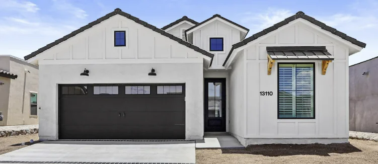 White farmhouse with black trim, a black garage door, and a black front door.