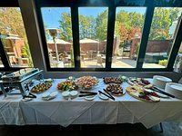 Buffet table with food, overlooking an outdoor patio.