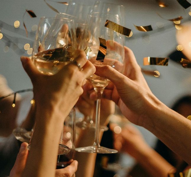 A group of people toasting with wine glasses and confetti