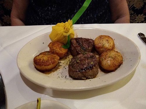 Filet mignon with scallops on a plate, served in a restaurant.