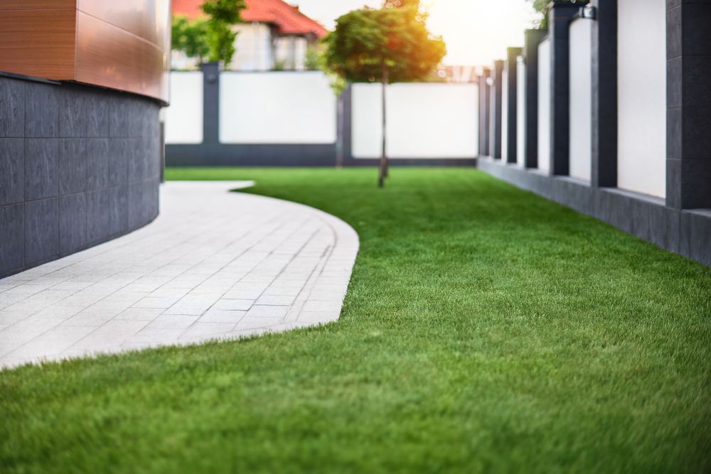 A Curved Paver Walkway Leads Through a Manicured Green Lawn — A Betta Fence 'N' Yard In Thrumster, NSW