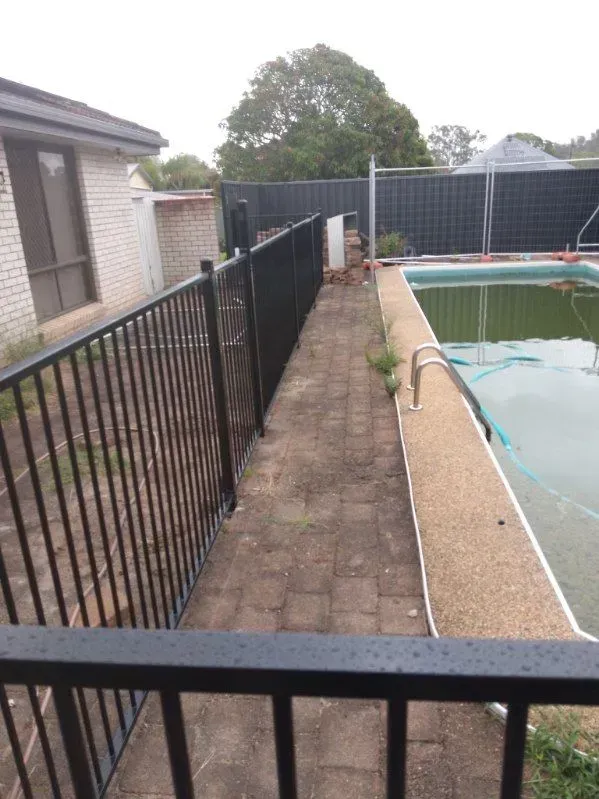 A Narrow Paved Walkway Beside a Pool — A Betta Fence 'N' Yard In Port Macquarie, NSW