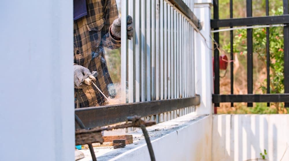 A Worker in a Plaid Shirt Uses a Welding Tool — A Betta Fence 'N' Yard In Port Macquarie, NSW