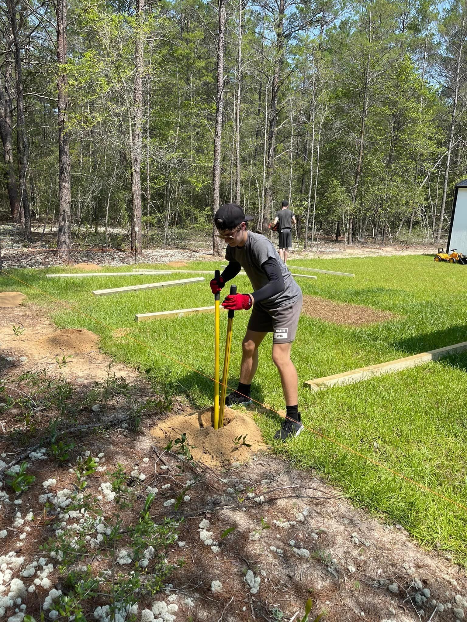 A man is using a drill to dig a hole in the ground.