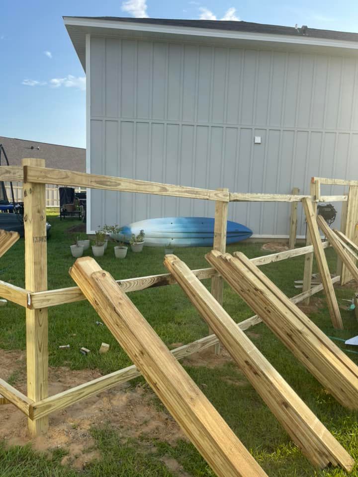 A wooden fence is being built in front of a house.
