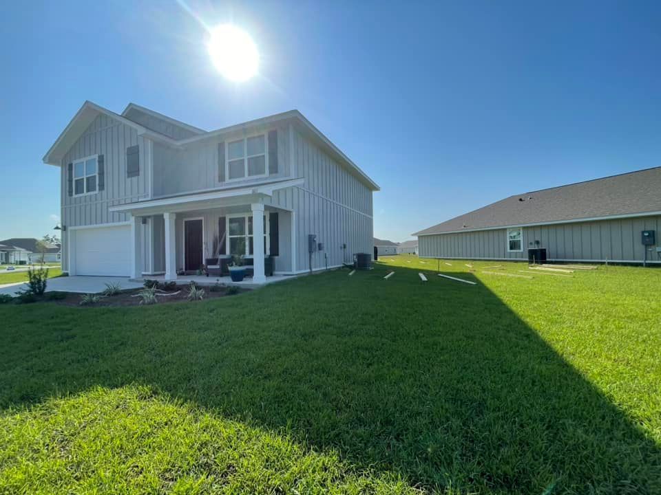 A large white house with a large lawn in front of it.