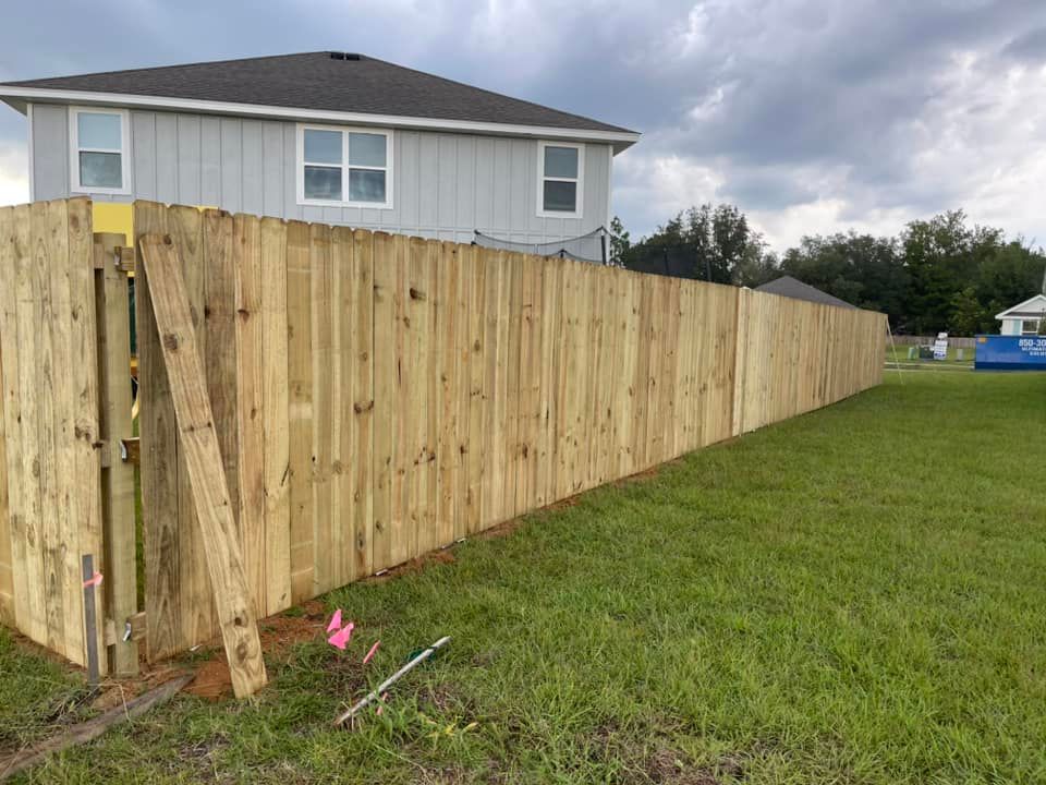 A wooden fence is being built in front of a house.
