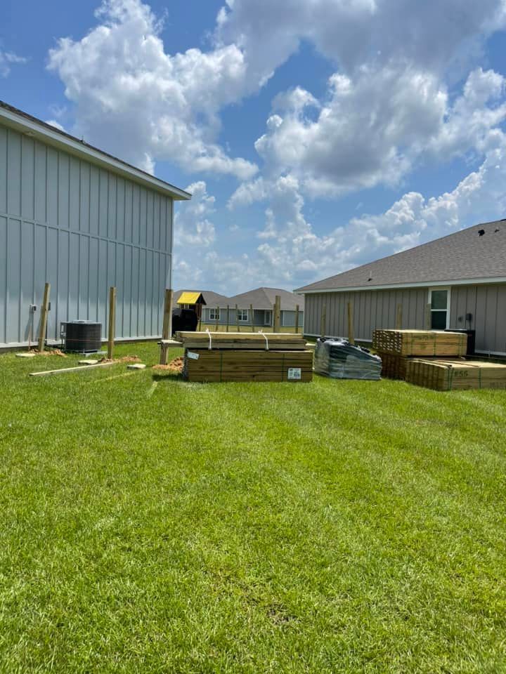 A backyard with a lot of grass and a house in the background.