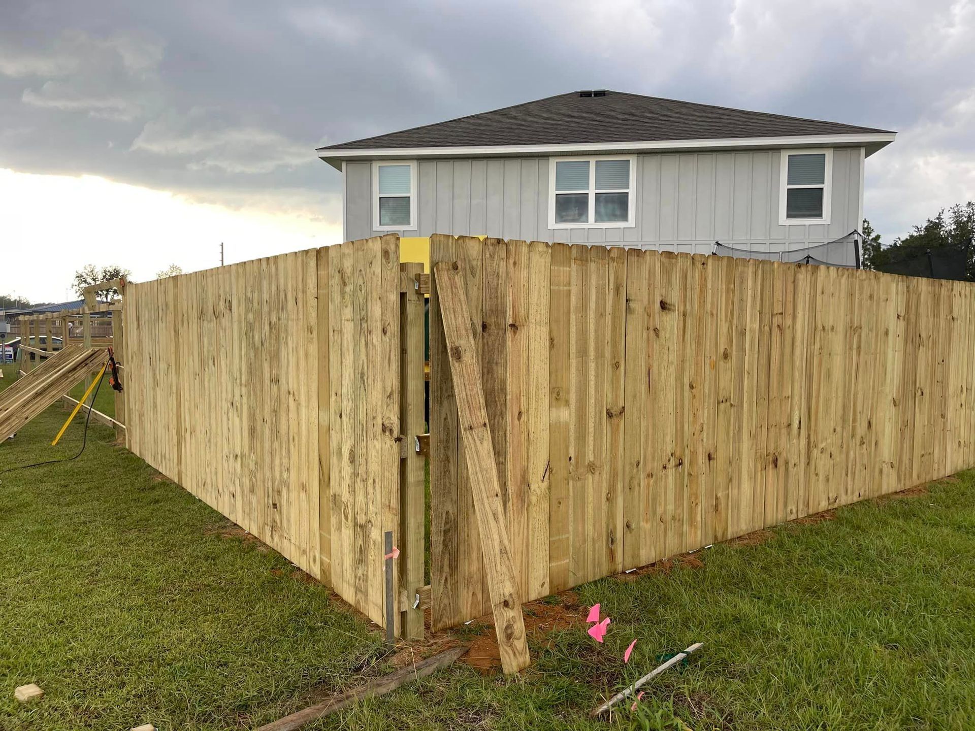 A wooden fence is being built in front of a house.