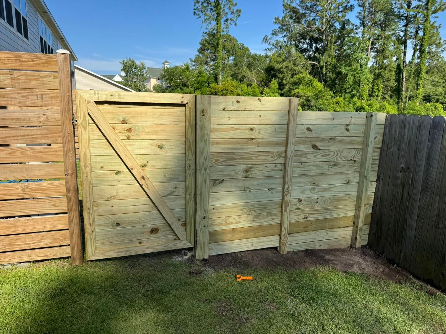 A wooden fence with a gate in the backyard.