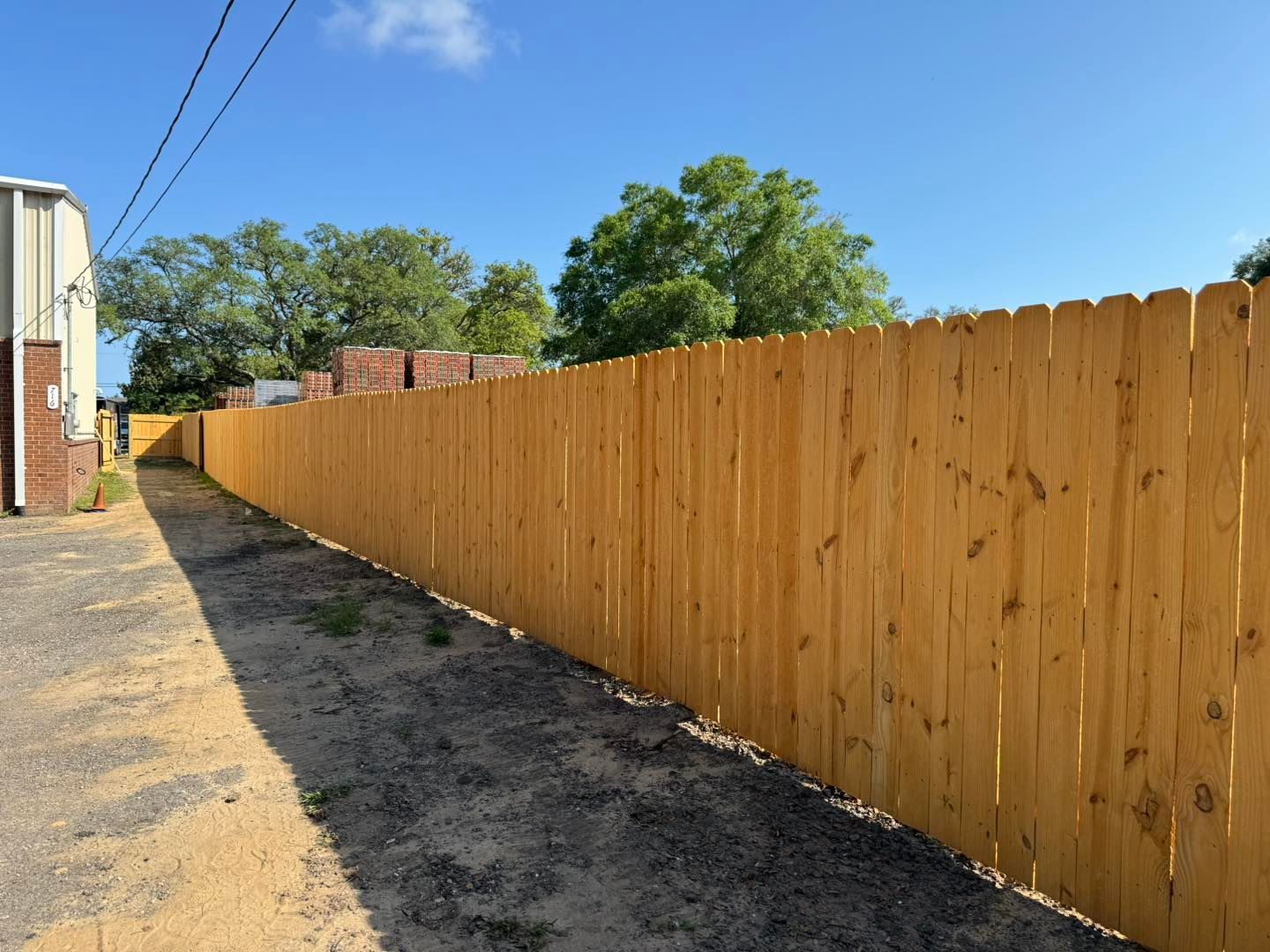 A long wooden fence along a dirt road