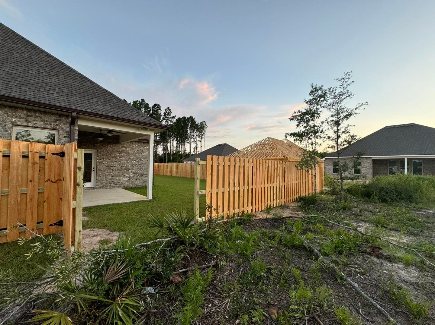 There is a wooden fence in the backyard of a house.