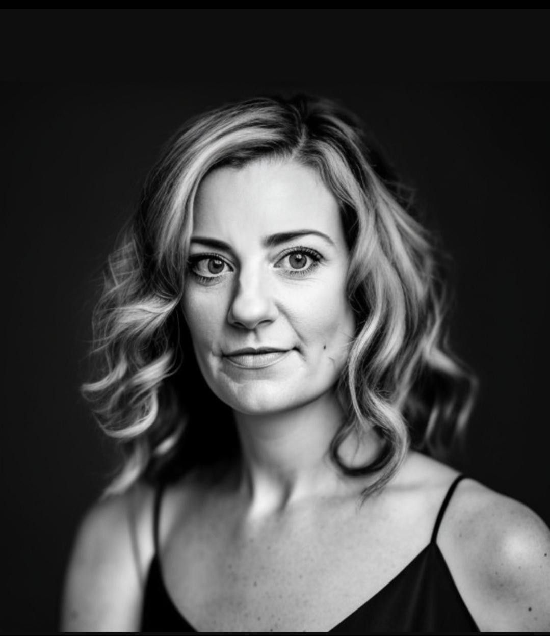 A woman with blonde hair against a black background