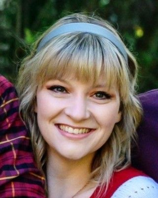 A woman wearing a headband is smiling for the camera.