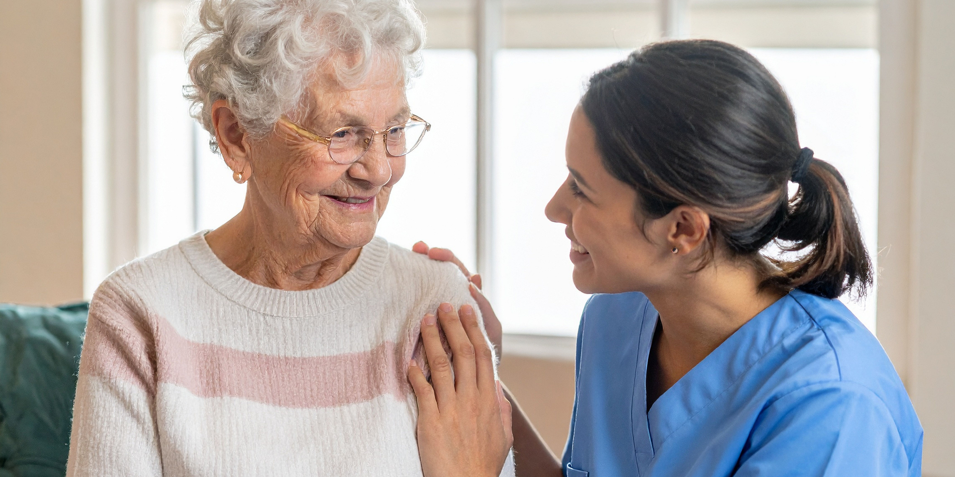 Family picnicking outdoors: four adults seated in chairs, conversing, while one man stands behind. Picnic basket on ground.