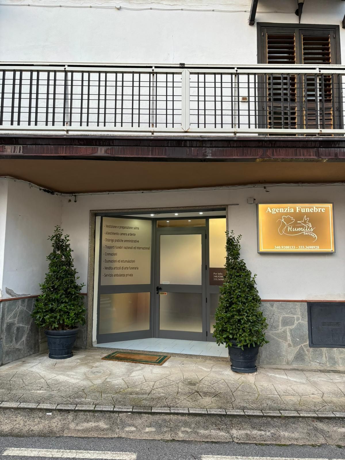 Un edificio con due piante in vaso di fronte