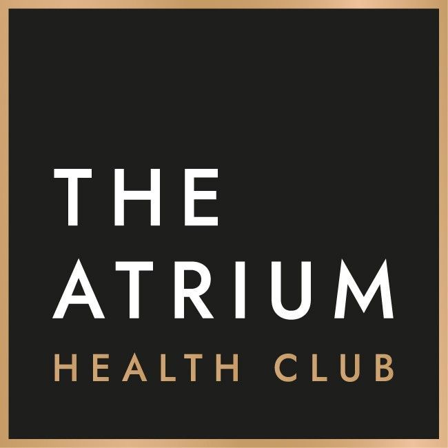 Logo for The Atrium Health Club with white text on a black background, framed in a gold border.