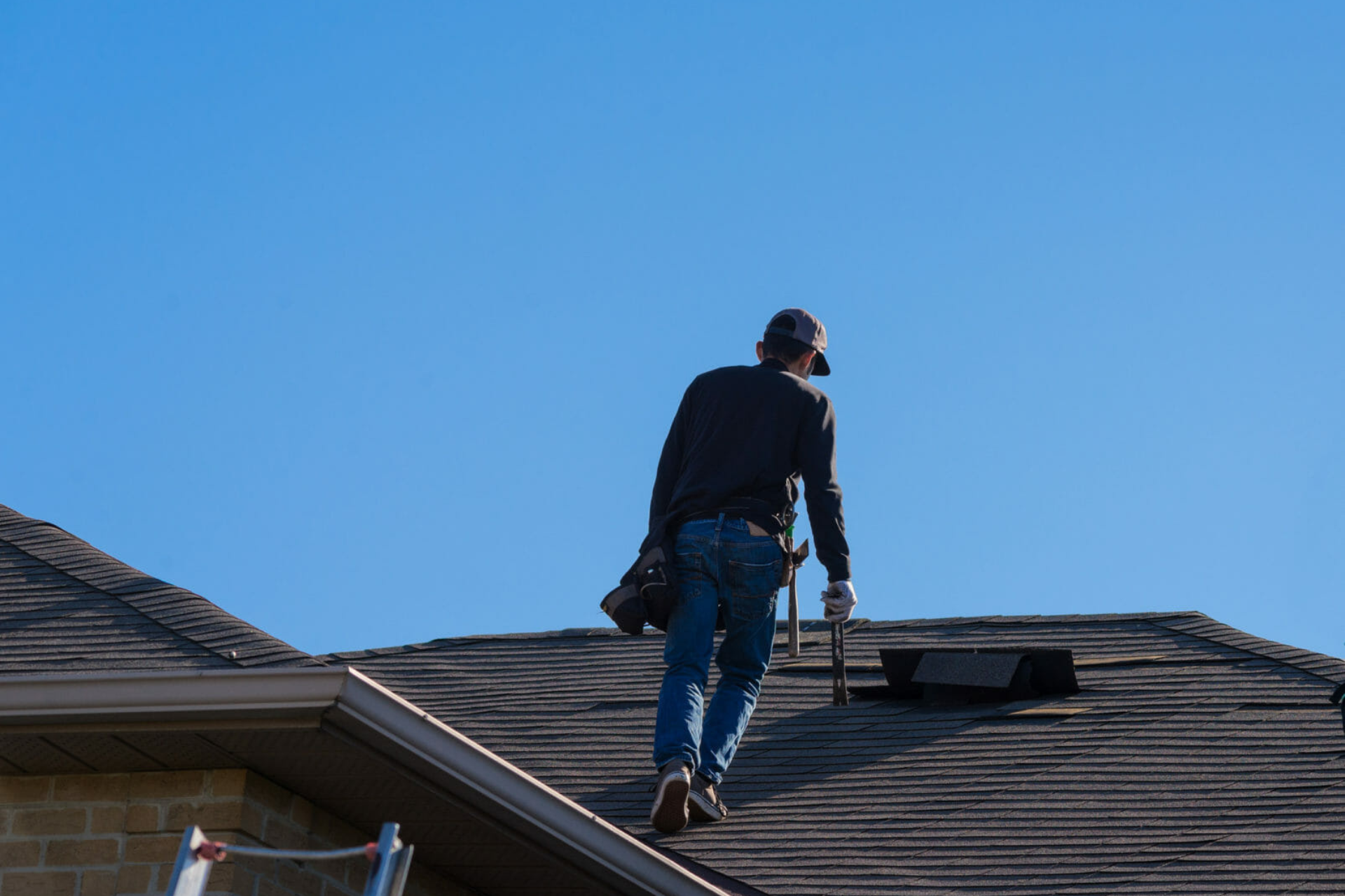 a man is standing on the roof of a house.