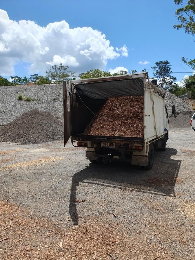 A Truck Filled With Wood Chips is Parked in a Gravel Lot — Arbaron Pty Ltd in Black Mountain, QLD