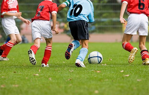 A group of young boys are playing soccer on a field.