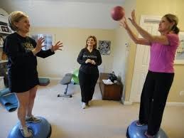 Three women are playing with a football in a room.