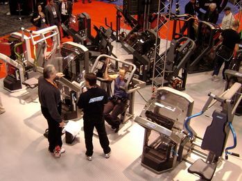 A group of people are looking at exercise equipment in a gym