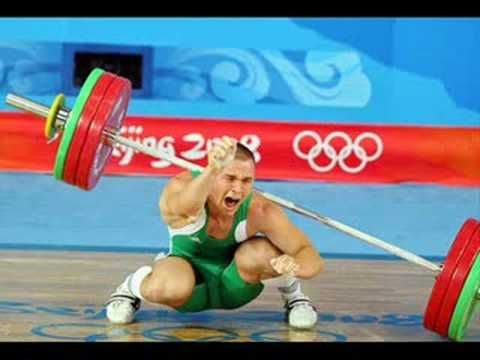 A man is squatting down while lifting a barbell.