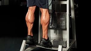 A man is doing calf exercises on a machine in a gym.