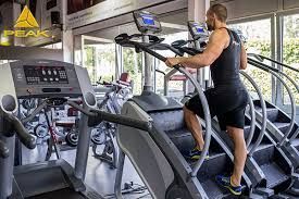 A man is walking up stairs on a treadmill in a gym.