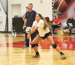 A woman is playing volleyball on a court.