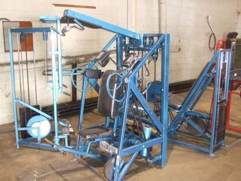 A blue gym machine is sitting in a garage.