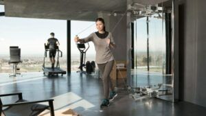 A woman is using a resistance band in a gym.